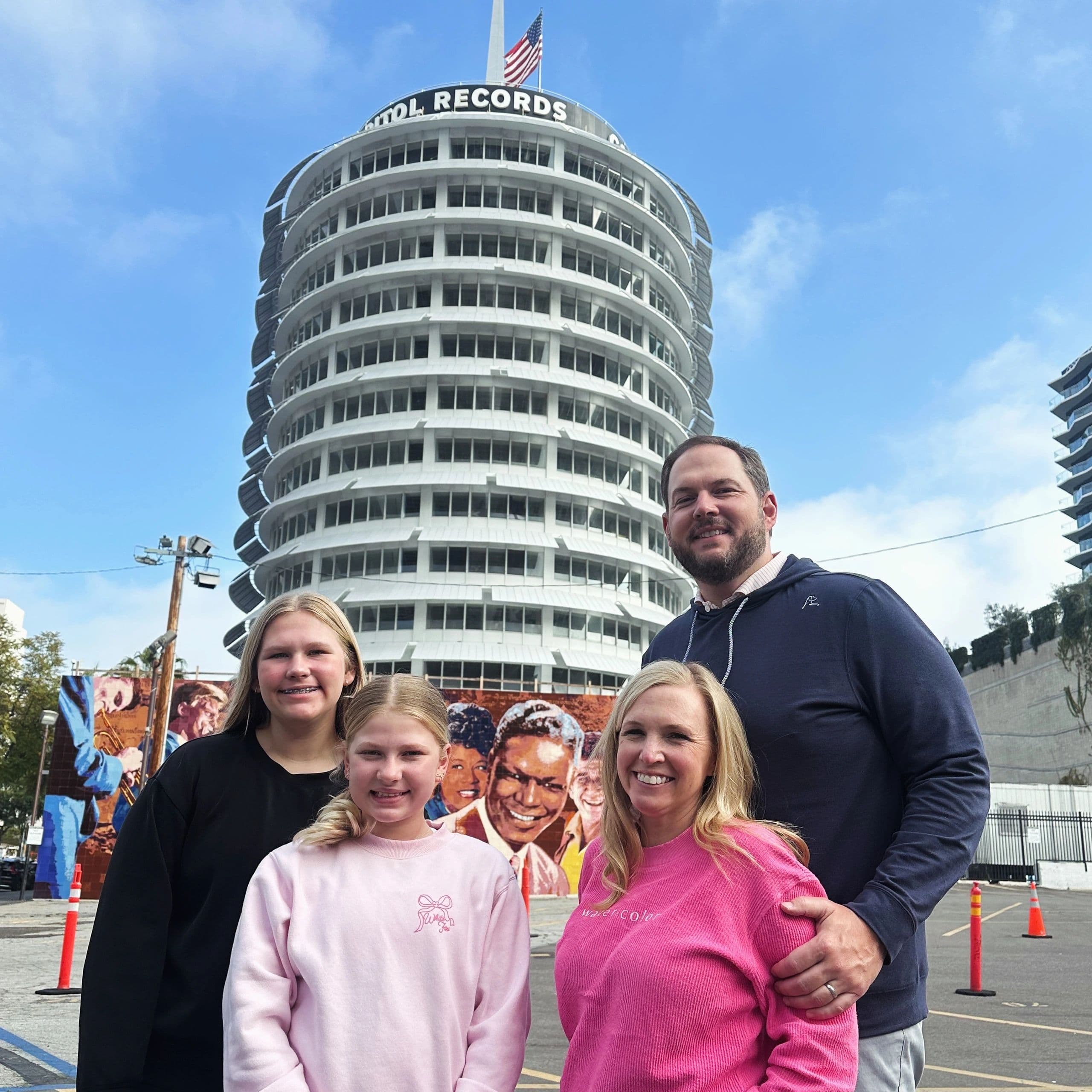 A family posing in front of the round Capitol Records building