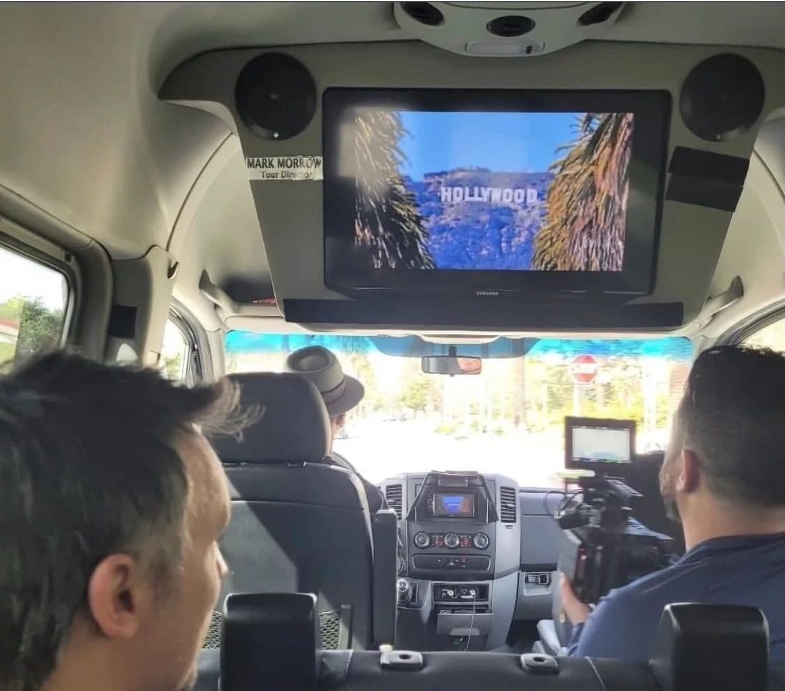 Inside an earlier Legends van: the overhead screen shows the Hollywood Sign while the van drives through Los Angeles